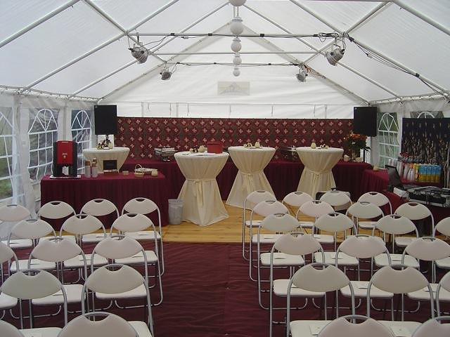 Trouwfeest onder een tent van 6 × 12 meter, met vloermatten, buffettafels en houten dansvloer.